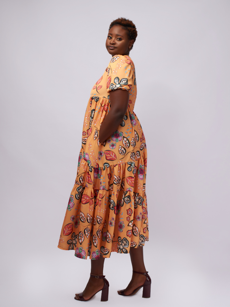 This midi dress features asymmetric gathered layers for a unique, flattering silhouette.