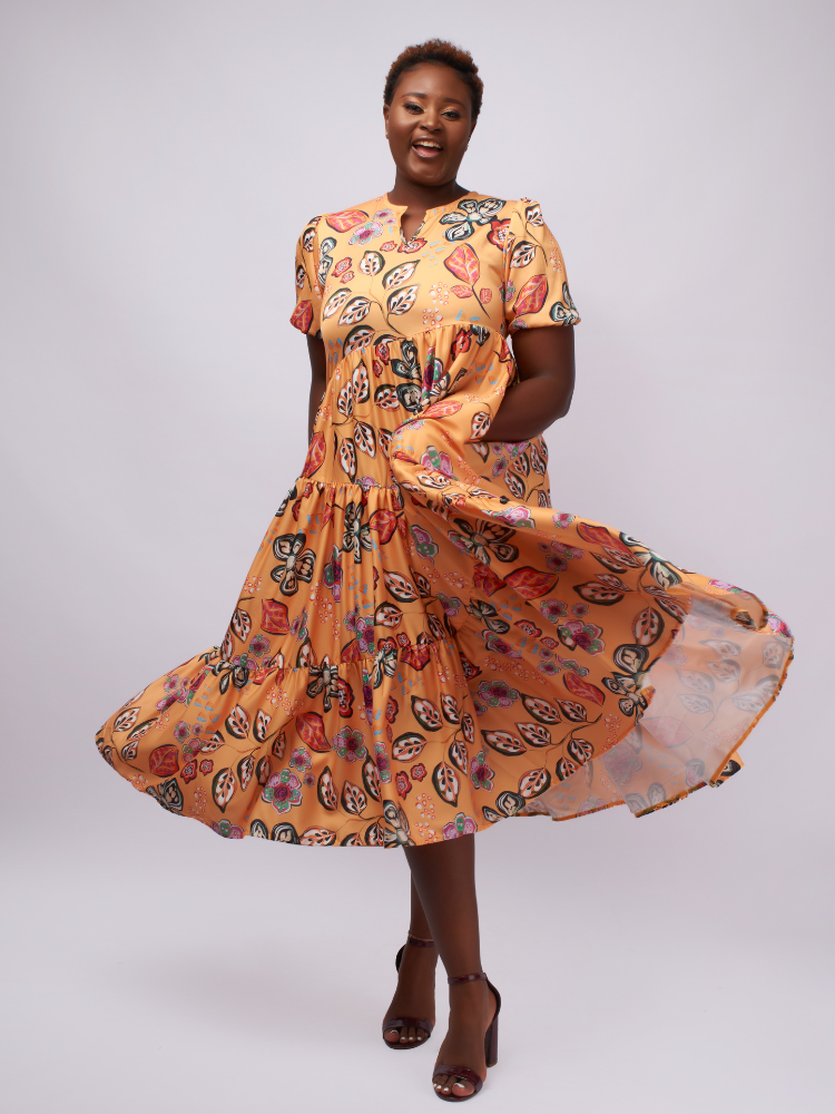 This midi dress features asymmetric gathered layers for a unique, flattering silhouette.