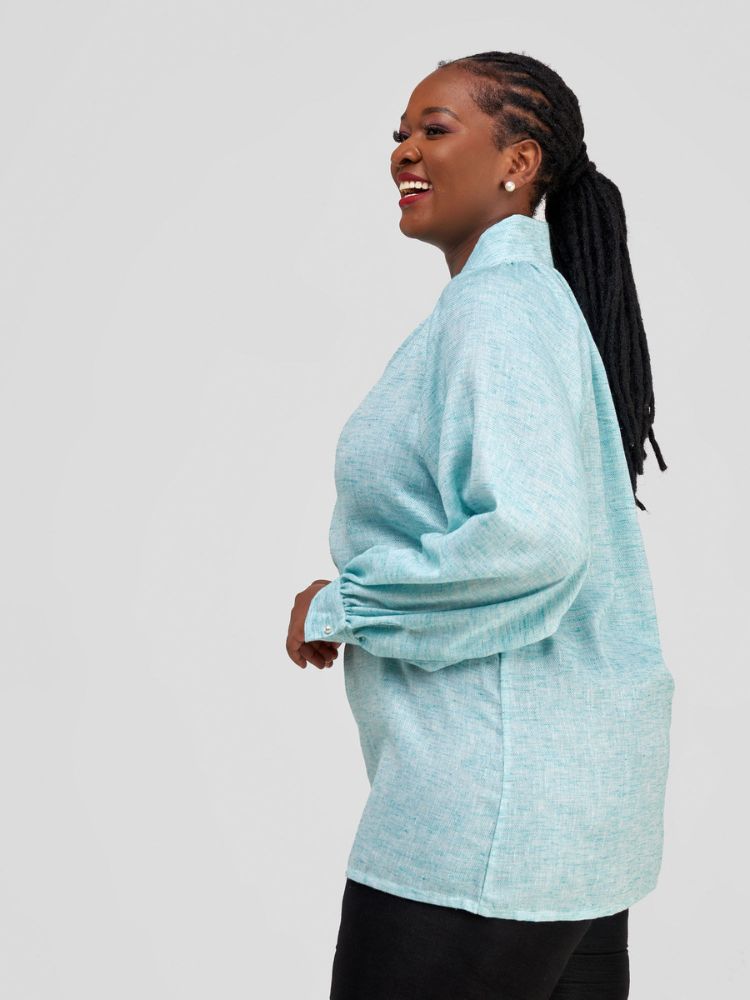 Hip-length blouse featuring long sleeves with stylish cuff details and a single button on each cuff.