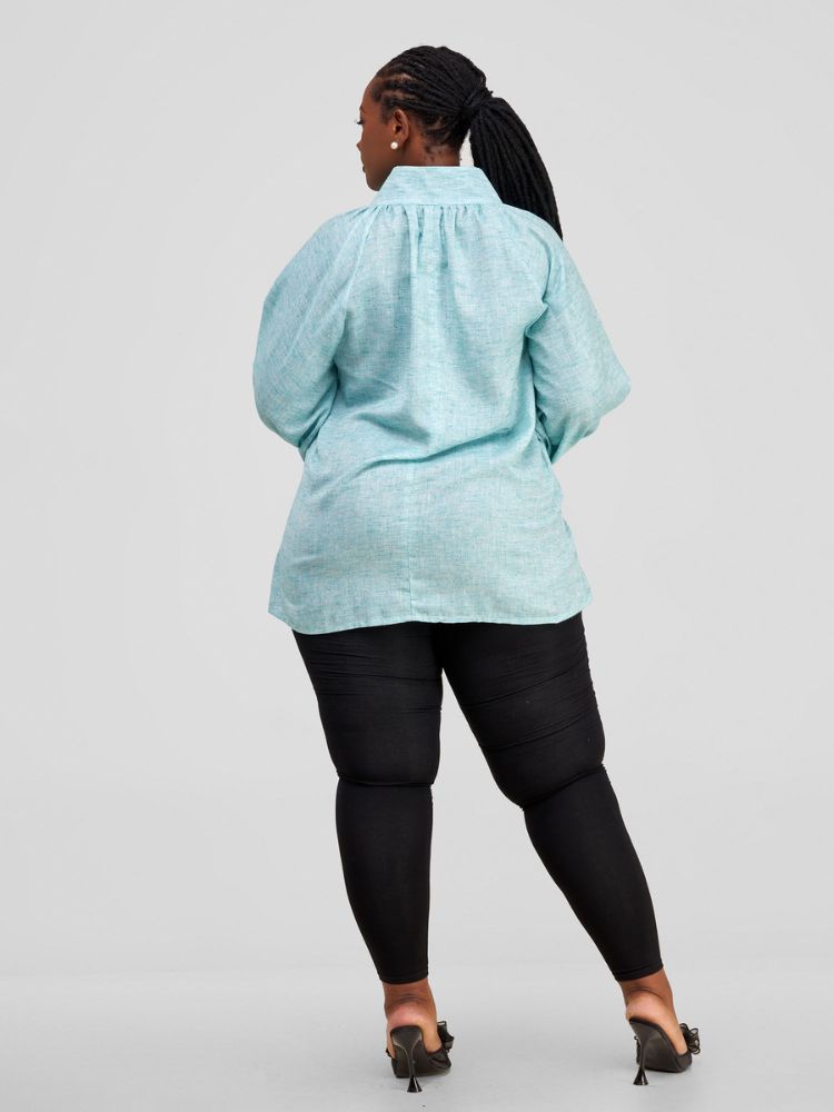 Hip-length blouse featuring long sleeves with stylish cuff details and a single button on each cuff.