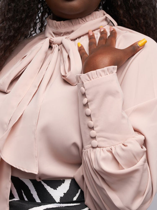 mock neck top boasts intricate frill detailing on the neckline and cuffs for a feminine touch.