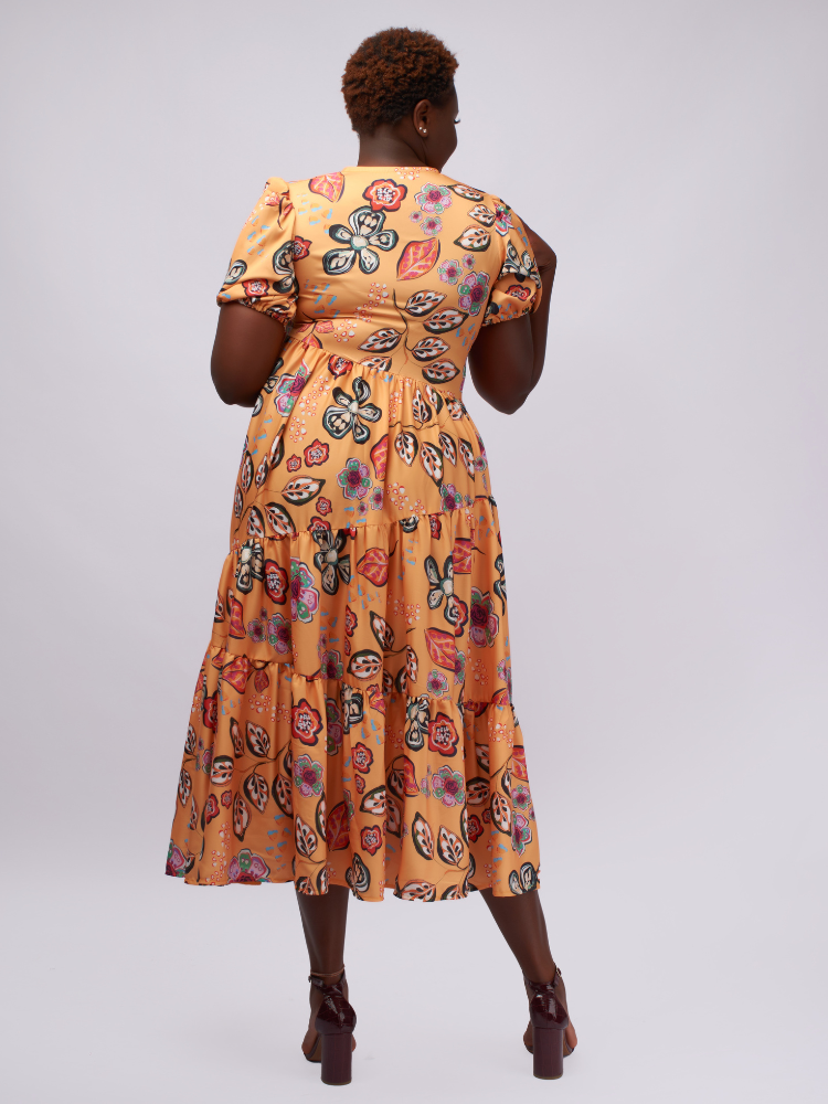 This midi dress features asymmetric gathered layers for a unique, flattering silhouette.