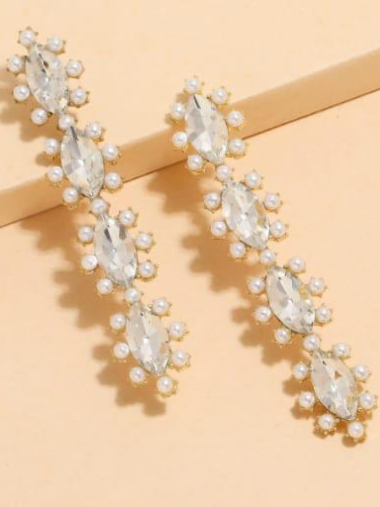 this pair of earrings is made of a central oval clear crystal surrounded by smaller round crystals.